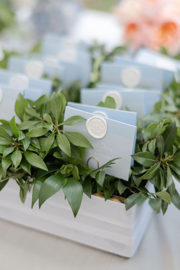 Escort cards featuring custom white wax seal; folded soft blue paper and custom calligraphy on vellum